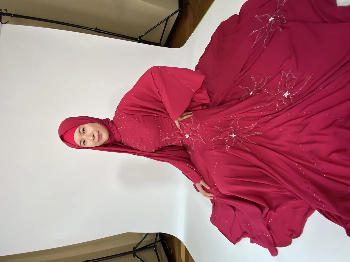 Model in a crimson beaded couture gown with beadwork and train